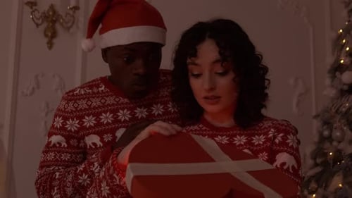 Loving Couple Opening Magical Christmas Gift Together