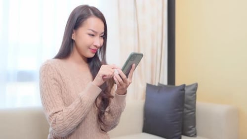 Woman Using Smartphone in Brightly Lit Home