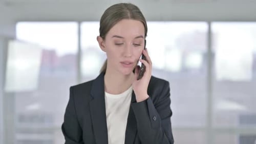 Young Woman in Business Suit Using Smartphone
