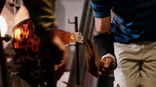 Glass Blower Shaping a Glass Vase with Tools