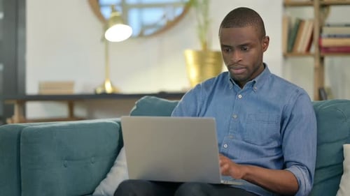 Man Typing on Laptop Computer at Home