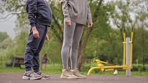 Mother and Daughter Doing Exercises on Open Air Sport Playground