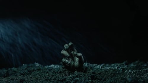 Muddy Hand Emerging from the Ground at Night
