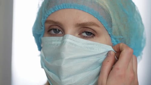 Medical Professional Removing Surgical Mask in Close Up