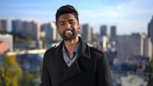 Smiling Man in Coat on City Rooftop