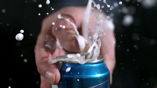 Hand Opens Soda Can with Beverage Erupting