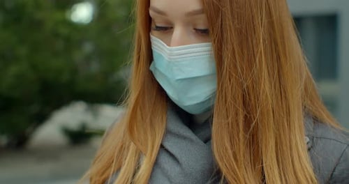 Close Up Portrait of a Beautiful Redhead Young Woman Wearing Protective Medical Face Mask