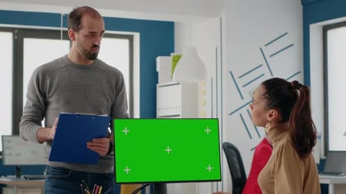 Workmates Using Computer with Green Screen on Display