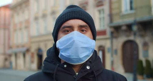 Close Up View of Man with Protective Mask Looking To Camera Standing at Street. Portrait of Young