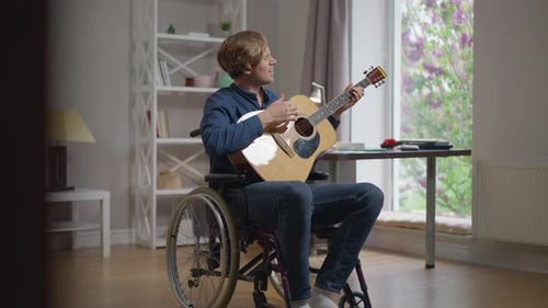 Man in Wheelchair Plays Guitar and Sings