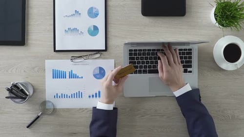 Business Person Inserting Gold Credit Card Number on Laptop Man Buying Company