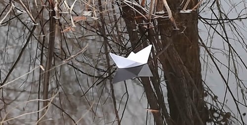Small Paper Boat Floating Gently on Calm Water