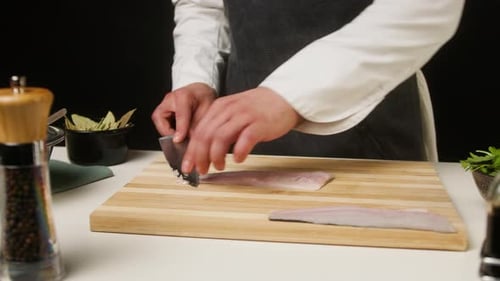 Chef Slicing Fresh Fish on Cutting Board