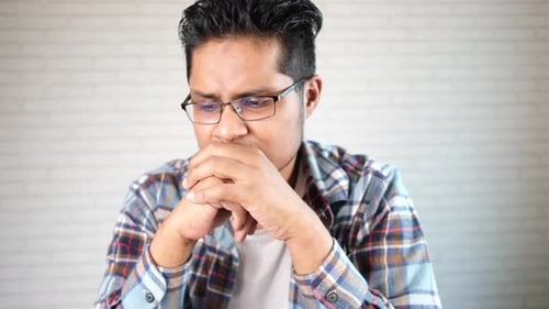 Young Adult Man Thoughtful With Worried Expression