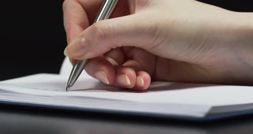 Close up of a hand writing on an agenda