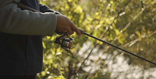 Angler Fishing with a Rod and Reel in Nature