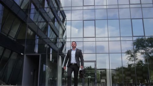 Confident Businessman Walking Toward Camera near Office Building