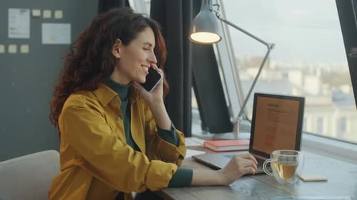 Cheerful Business Lady Talking on Mobile Phone in Office