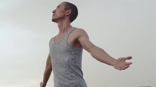 Young Man Stretching Arms to Open Sky