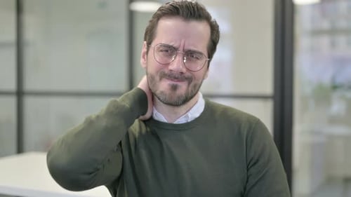 Man Rubs Stiff Neck in Office Close Up