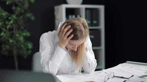 Stressed Woman Working at Desk with Head in Hands