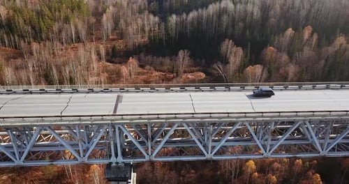 Aerial View of Cars Traveling Along the Road in Colorful Autumn Forest.