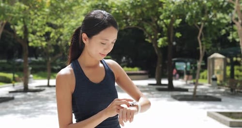 Woman Checking Smart Watch in Park