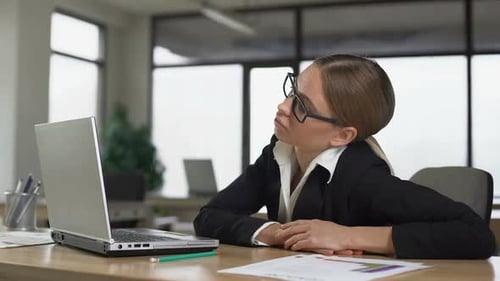 Jeune femme qui s'ennuie de travailler à l'ordinateur au bureau épuisée et démotivée