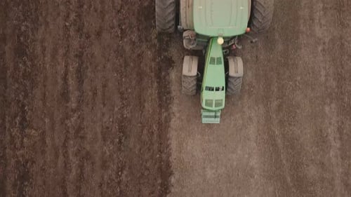 a Large Tractor Plows a Field