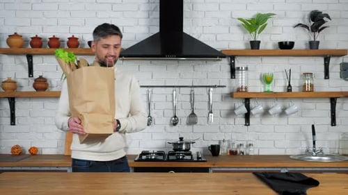 Man Arriving Home With Groceries in Kitchen