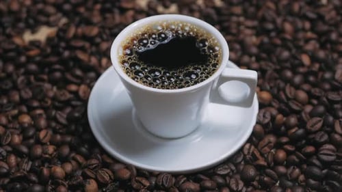 Cup of Coffee on Coffee Bean Background