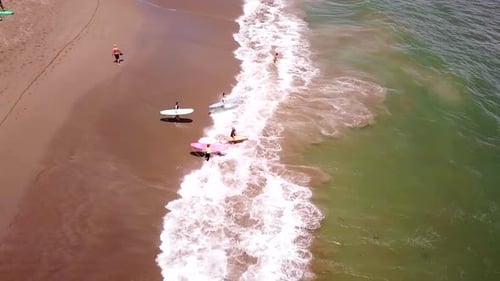 Aerial Shot of Surfers Conquering Ocean Waves