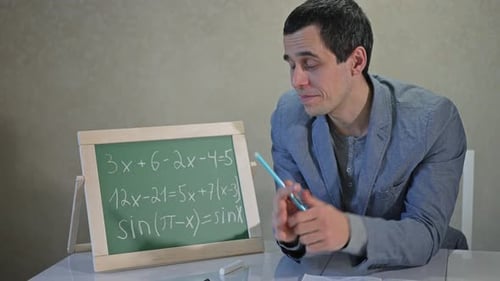 Man Explains Math Equations on Chalkboard
