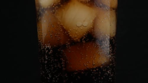 cola with ice cubes close up