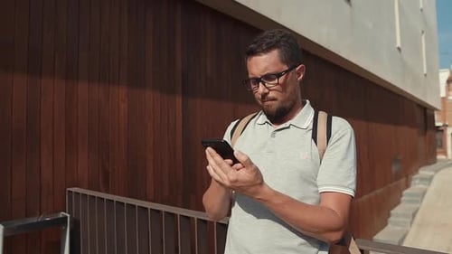 Man Uses Smartphone in Urban Setting