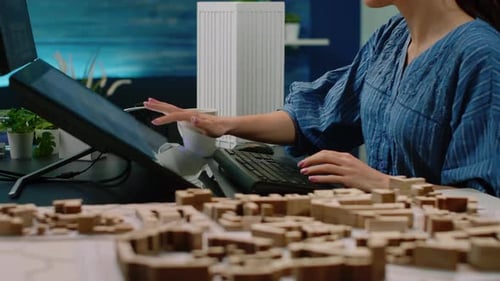 Close Up of Hands Using Touch Screen Monitor with Building Model
