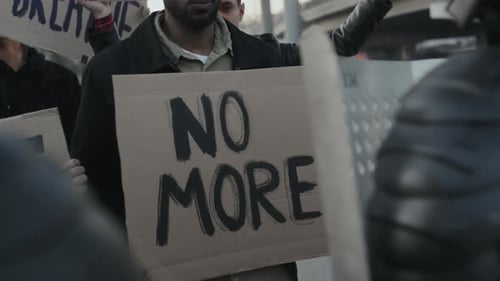 Protesters Holding Signs and Demonstrating in Urban Setting