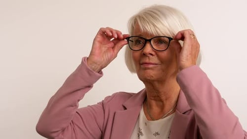 Mature Woman Puts on Different Pairs of Glasses