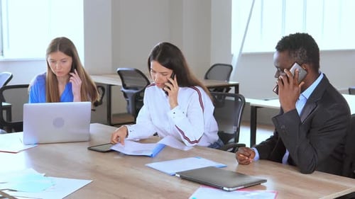 Office Workers Talking on Phone at Conference Table