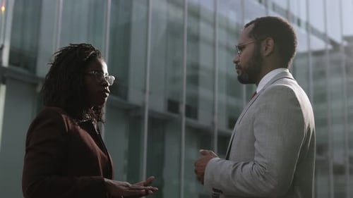 Side View of Two Confident Managers Talking Outdoor.