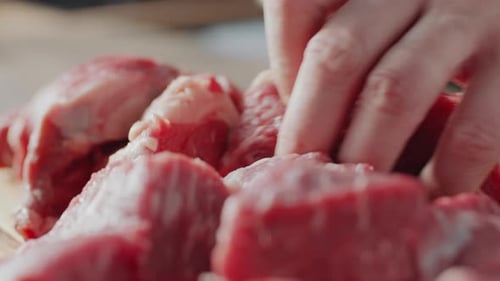 Cutting Raw Meat on Wooden Surface Close Up