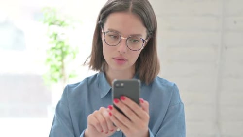 Young Woman Using Smartphone Device Indoors