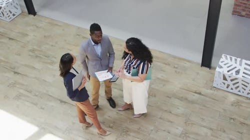 Diverse group of business people working together, discussing work in modern office