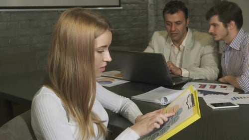 Woman Reviews Business Plan at Corporate Meeting