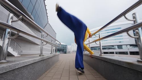 Free Running Young Man Runs Over Obstacles in the City and Doing a Flips on Training Area Near