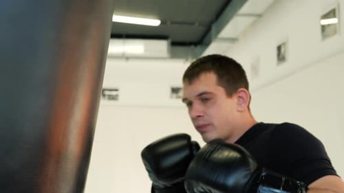MMA Fighter Boxers Doing Some Training on a Punching Bag at a Gym Close Up Power Punch Kicks Macro