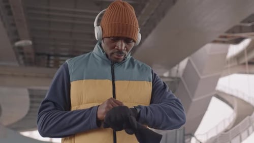 Man Uses Smart Watch Wearing Headphones Outdoors