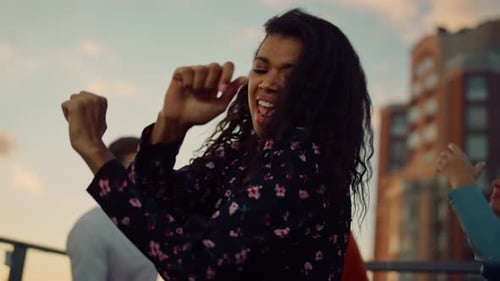 Young Woman Dancing with Friends at Sunset Party