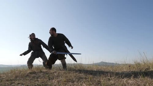 Medieval Warriors Engage in Intense Sword Fight on Hilltop