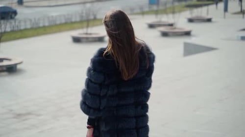 Stylish Woman in Fur Coat Walking in City